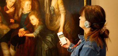 Person mit Audioguide und Kopfhörer im Stadtmuseum