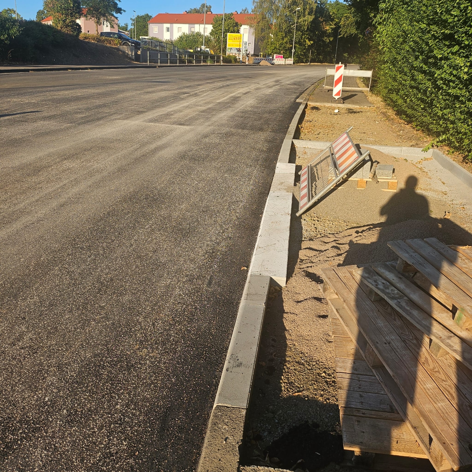 Blick auf die Steinhauser Straße mit neuer Asphaltdecke, mit Blick auf den Netto-Markt